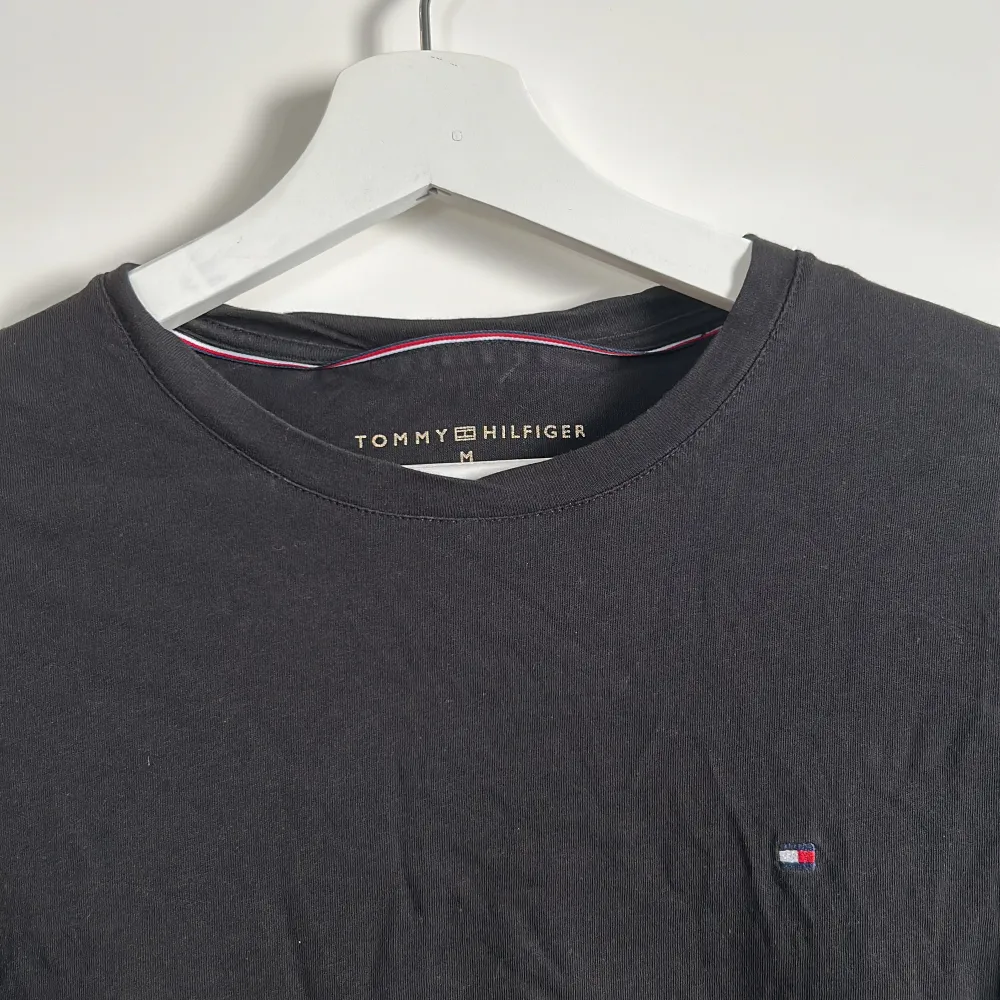 Säljer en stilren svart långärmad tröja från Tommy Hilfiger. Tröjan har en liten logga på bröstet och är perfekt för både vardag och lite finare tillfällen. Den är i bra skick och superbekväm att ha på sig. Passar perfekt till jeans eller chinos!. Neuletakit & Villapaidat.