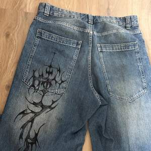 Blåa jeans med snygg tvätt och mönster på bakfickan  Det är byxor från bershka som jag har målat på