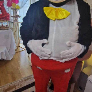 Musdräkt med röd byxa och gul fluga - Säljer en rolig musdräkt perfekt för fest eller maskerad! Dräkten har en svart kavaj, vita handskar, en stor gul fluga och röda byxor med vita knappar. Den är bekväm och lätt att röra sig i. Perfekt för att göra succé på nästa party!