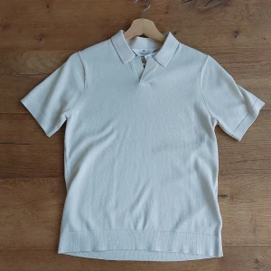 Beige pikétröja från H&M - Säljer en stilren beige pikétröja från H&M. Perfekt för både vardag och lite mer uppklädda tillfällen. Tröjan har korta ärmar och en klassisk krage. Materialet känns mjukt och bekvämt, vilket gör den skön att bära hela dagen. Passar bra till både jeans och chinos! Inte använd! Står 146-152 men är själv 155 och tycker den är allt förstor. skulle recomendera 160-170😃 NYPRIS 179, men kan diskuteras!