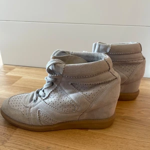 Sneakers i mocka - Säljer ett par snygga pavement kilklack sneakers i mocka med snörning. De har en cool perforerad design och en bekväm gummisula. Perfekta för en avslappnad stil! Använda men i bra skick. 