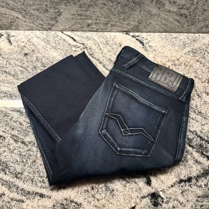 Replay jeans  - Ett par Replay anbass i nyskick, storlek W34 men viktigt att veta att dessa är lite mindre i storleken, tvättlappen är avklippt. Perfekta jeansen för dig som vill vara fräschast på festen🕺