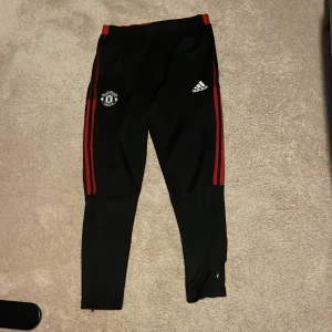 Manchester United byxor  - Manchester United byxor. Några hål (som givetvis går att laga), fråga om bild på dem om det önskas. Annars bra skick.