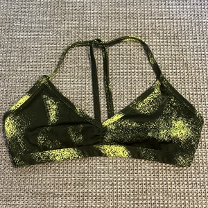 Gymshark topp - Sport-bh från Gymshark med öppen rygg. Ett av banden fattas men det är inget som påverkar hur den sitter. Jag har sytt upp den i bandet runt halsen. Storlek M men mer som en S🥰