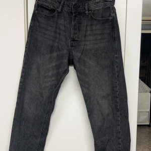 Jack & Jones jeans loose 30/32 - Säljer ett par svarta jeans i loose fit-modell från Loose Chris. De har en klassisk femficksdesign och är perfekta för en avslappnad stil. Jeansen är i bra skick och passar perfekt för både vardag och fest. Storlek 30/32.