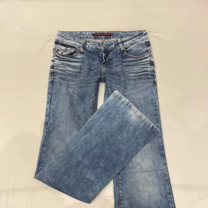 Blå bootcut jeans -  snygga blå bootcut jeans i bra skick. De är lågmidjade och har jätte cool desing på fickorna. Ja säljer för ja har för många i just den färgen annars ja älskar dem. Midja rakt över: 39cm o jae 172 o de passar perfekt 