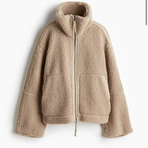 Beige teddyjacka hm - Mysig beige teddyjacka i oversized stil med dragkedja framtill. Perfekt för höst och vinter, håller dig varm och trendig. Jackan har långa ärmar och en hög krage för extra komfort. Perfekt för att mysa till vardags eller en chill dag ute. Från hm ❤️ny med prislapp på! 