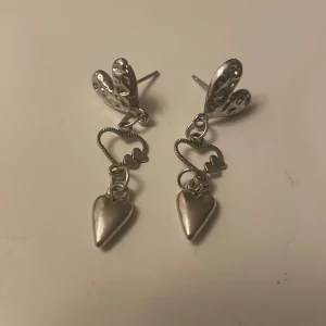 Söta silverörhängen med hjärtan - De har en fin hjärtformad detalj som hänger från en dekorativ ögla. Används inte längre. 