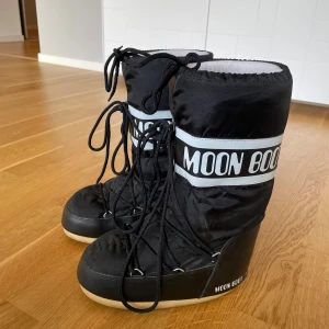 Svarta Moon Boots - Säljer ett par svarta Moon Boots i bra skick. De är använda en vinter! Passar mig som har storlek 38