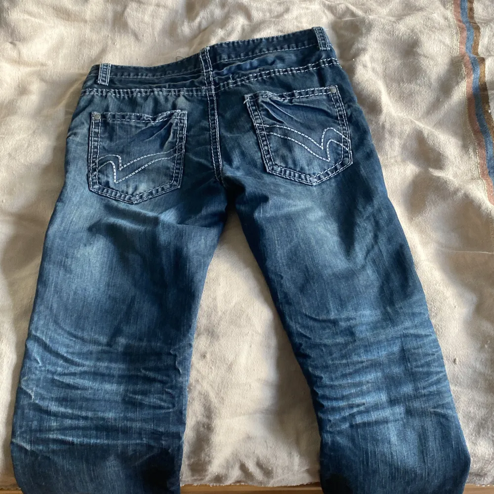 Säljer ett par snygga blå jeans från Clockhouse. De har en klassisk femficksdesign med coola sömmar på bakfickorna. Perfekta för vardagsbruk och passar till det mesta. Dragkedja och knapp framtill. Sköna och stilrena!. Jeans & Byxor.