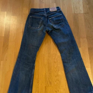 Levi's 555 Jeans - Säljer ett par klassiska Levi's 555 jeans i marinblå denim. De har en straight/bootcut passform och är i mycket bra skick. Perfekta för både vardag och fest! 👖🕺
