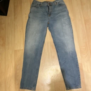 Blå jeans från Nudie Jeans - Säljer ett par klassiska blå jeans från Nudie Jeans i bra skick. De har en straight passform och är tillverkade i slitstarkt denim. Perfekta för vardagsbruk och kan matchas med det mesta. Dragkedja och knapp framtill.