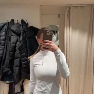 Vit långärmad Relode - Säljer en snygg vit långärmad tröja från Relode. Den har en halv dragkedja framtill och är perfekt för både träning och vardag. Tröjan är i ny skick och har en tight passform. Nästintill helt oanvänd, max använt 4ggr! 