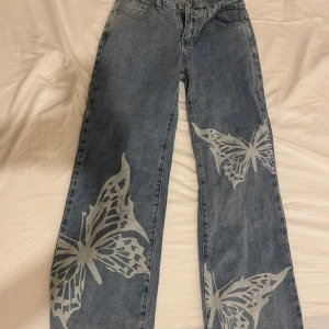 Lågmidjade jeans - Lågmidjade blåa utsvängda jeans med fjärilar 