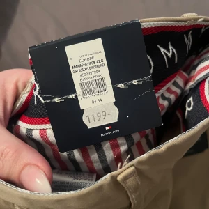 Beige byxor från Tommy Hilfiger - Säljer ett par snygga beige byxor från Tommy Hilfiger i modellen Bleecker. De har en slim fit och är tillverkade i stretchmaterial för extra komfort. Perfekta för både vardag och fest! 🕺