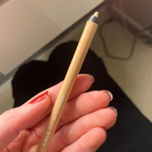 CAIA Eye Brightener - Säljer en CAIA Eye Brightener i en ljus nyans. Perfekt för att ljusa upp ögonen och ge en piggare look. Pennan är lätt att använda och har en krämig konsistens som glider smidigt på huden. Perfekt för vardagsmakeup eller en mer dramatisk look. Endast testad 