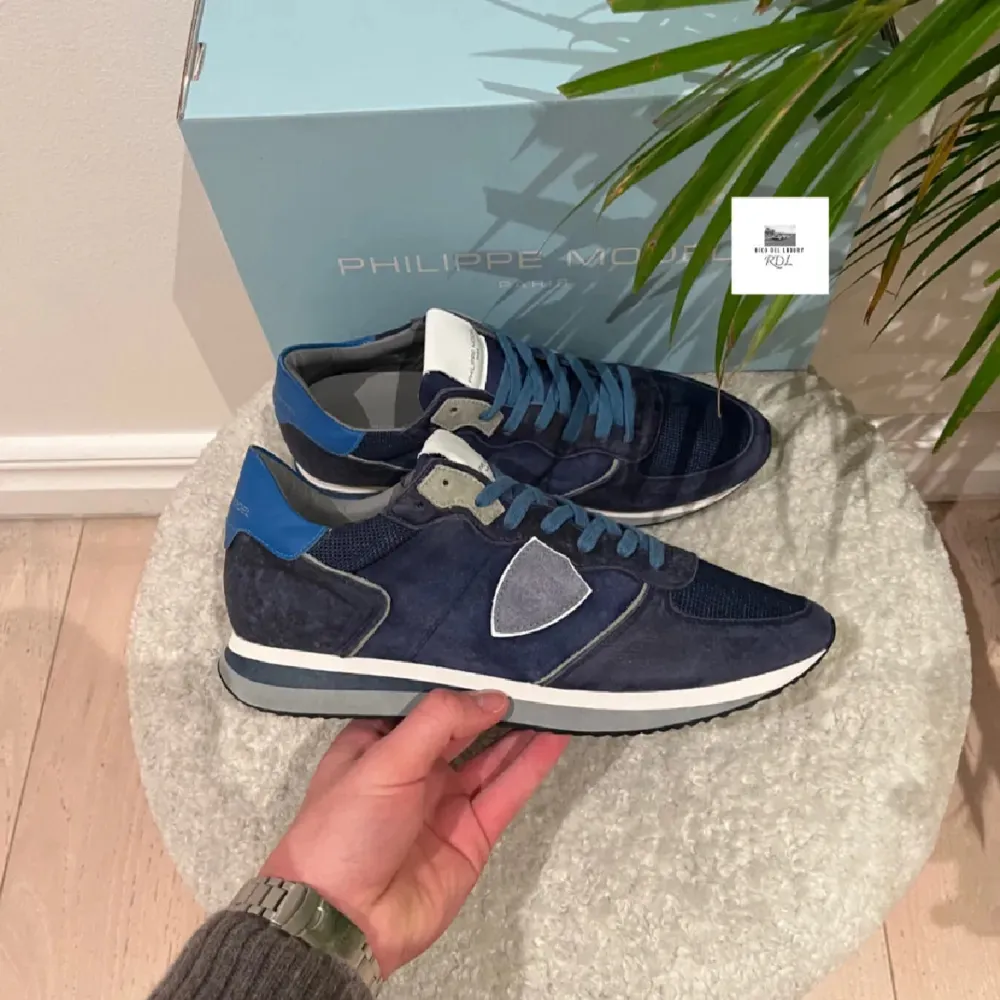 Säljer ett par snygga blå sneakers från Philippe Model, perfekta nu till vintern och våren | HELT NYA | STORLEK 42 | Box medföljer| Fraktar genom både PostNord och Instabox på köparens bekostnad | Det är bara att kontakta vid minsta fråga eller fundering! 🤝. Skor.