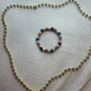 Armband med stjärnor  - Säljer ett coolt armband med blå stjärnor och beige, vita pärlor. Perfekt för att ge en bohemisk touch till din outfit.smycket är i mycket bra skick och kan bäras till både vardag och fest.