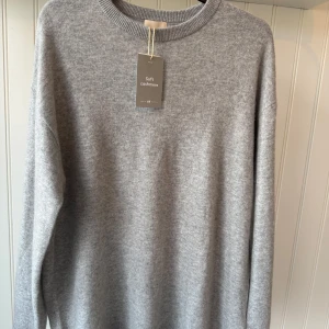 Grå kashmirtröja från Soft Cashmere - Supermjuk och stilren grå kashmirtröja från Soft Cashmere. Perfekt för kyliga dagar med sin långärmade design och klassiska passform. Ett måste för garderoben om du älskar lyxigt och bekvämt material. 🧶✨