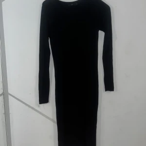 Svart långklänning från Å - Snygg svart långklänning från Å i storlek XS. Den är långärmad och har en tight passform som framhäver figuren. Perfekt för höst och vinter, både till vardags och fest. Materialet känns mjukt och bekvämt mot huden.