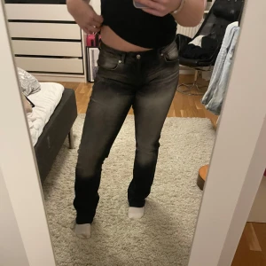 Svarta jeans med tvättad effekt - Säljer ett par svarta jeans med en cool tvättad effekt. De har en normal passform och är perfekta för både vardag och fest. Jeansen har klassisk femficksdesign och knappgylf. De är i mycket bra skick och redo för en ny ägare!🖤