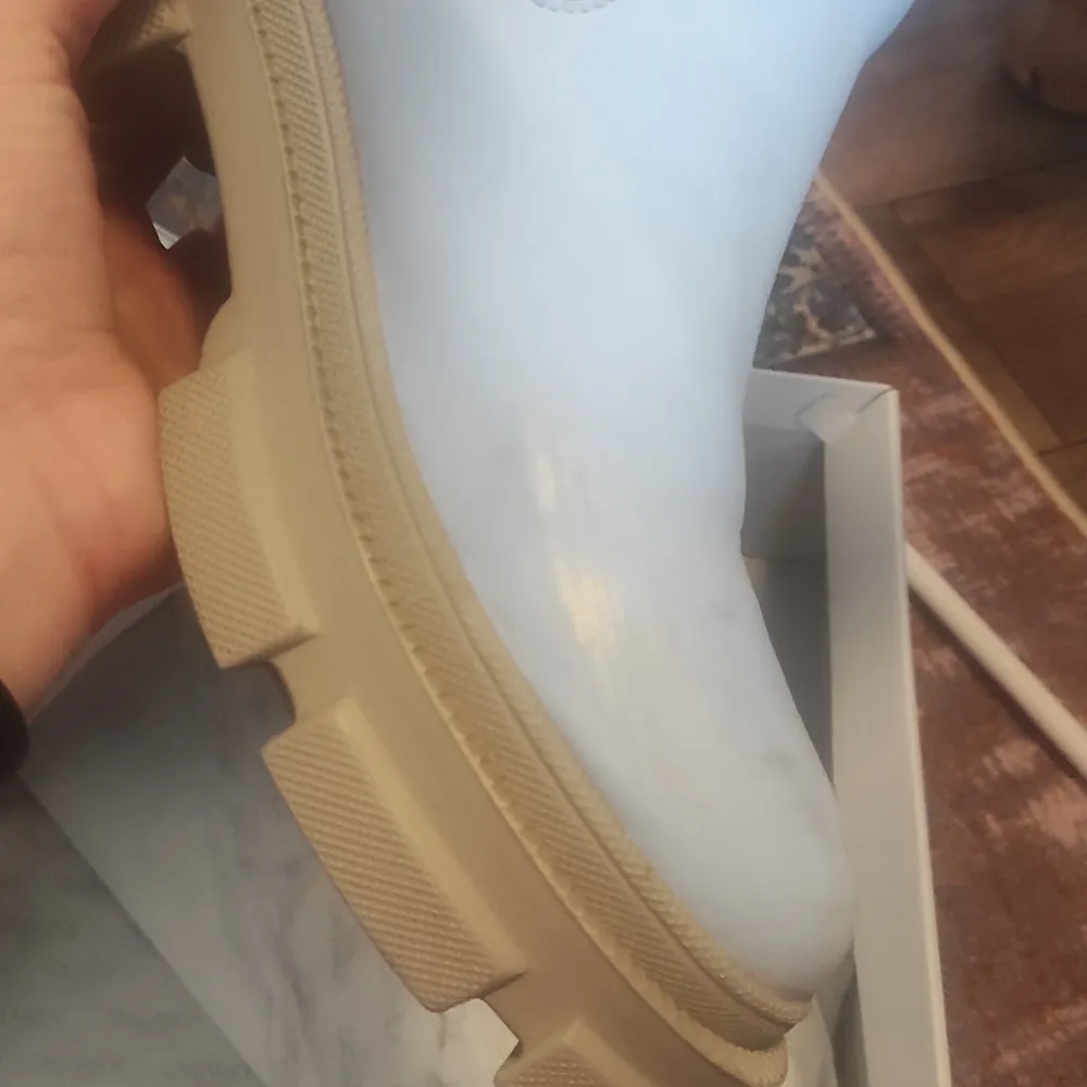 Säljer ett par ljusblå boots i syntetmaterial med en rejäl beige sula. Perfekta för att ge din outfit en cool touch. De är i bra skick och passar perfekt för höst och vår. Skorna har en stilren design utan snörning. Den har blivit skrapad på ena skon. Det är därför den säljs så billigt. Den har blivit använd endast 2 ggr. Skor.