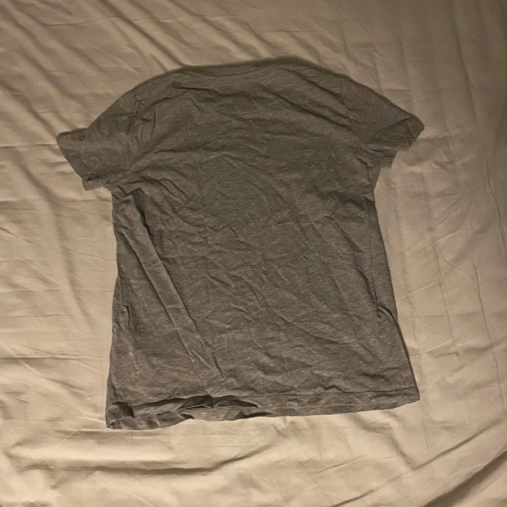 Säljer en grå t-shirt från Lyle & Scott i juniorstorlek 12/13. Den har en liten gul logga på bröstet och är i bomull. Perfekt för vardagsbruk och passar till allt! Skön och enkel stil för alla tillfällen. . T-paidat.