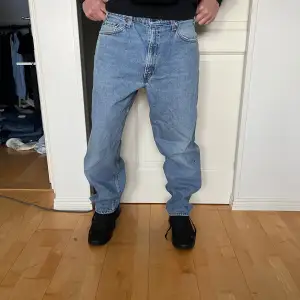 Säljer ett par klassiska Levi's 550 jeans i ljusblå denim. De har en relaxed fit och är perfekta för en casual look. Jeansen är i mycket bra skick och har den ikoniska Levi's-lappen på baksidan. Perfekta för både vardag och avslappnade tillfällen.