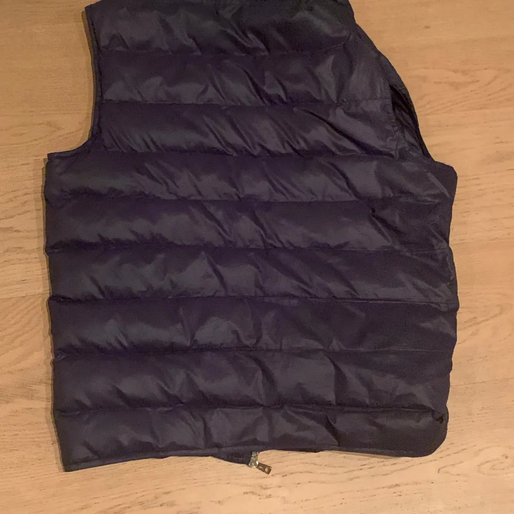 Säljer en snygg och varm mörkblå dunväst från Moncler. Västen har en dragkedja framtill och två praktiska fickor med dragkedjor. Perfekt för vår och höst. Den är i mycket bra skick och passar både till vardags och lite finare tillfällen. Den är bara något liten för mig som är 186. Storlek 2 i Moncler som jag tror motsvarar S/M, men jag skulle säga att den är något större i storleken, då jag fortfarande kan ha den. Väldigt bra skick inga repor och andra tecken på att den har varit använd.. Jackor.