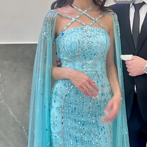 Turkos glittrig klänning - Säljer en fantastisk turkos klänning med glittriga detaljer och broderier. Klänningen har en tight passform och är perfekt för festliga tillfällen. pärlor kan ha ramlat av. Använd en gång. Köpt för 6500 kr. Mitt pris 2999 kr. Pris kan diskuteras. Storlek 32 men jag som har har storlek 34-36 passar den perfekt. Färgen är som på första bilden, dvs turkos.