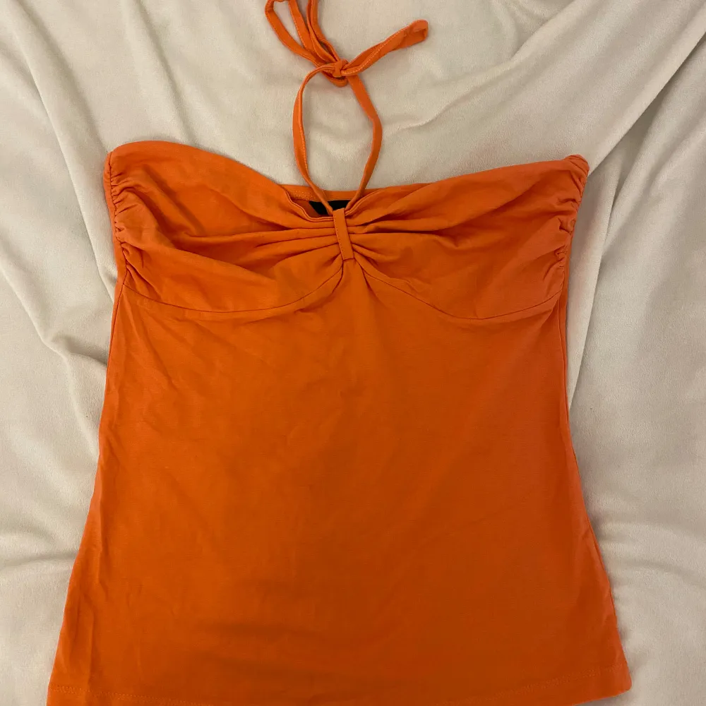 Säljer en snygg orange tubtopp från H&M i storlek M. Toppen har en knytning runt halsen och är perfekt för sommardagar. Den är i bra skick och passar både till vardags och fest. Perfekt för att liva upp garderoben med en färgklick! 🧡. Toppar.