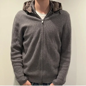 Massimo dutti cardigan - Säljer min as feta massimo dutti cardigan i färgen grå med en oliv aktig luva som man kan ta av ifall man vill. Perfekt för höst och vår, med långärmade ärmar och en bekväm passform. Jackan är i bra skick och passar både till vardags och lite mer avslappnade tillfällen.