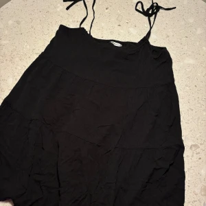 Svart klänning från Hollister - Säljer en svart klänning från Hollister i storlek M. Klänningen har smala axelband och en enkel, stilren design. Perfekt för både vardag och festliga tillfällen. 🖤