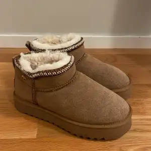 Supermysiga bruna boots från Mexx i nytt skick. De är fodrade med fluffigt vitt material som håller fötterna varma under kalla dagar. Perfekta för höst och vinter! Bootsens yttre är i mocka och de har en snygg stickad detalj runt öppningen. Köpta second hand men inga tecken på användning. Det står stl 40 men passar 39 🤩