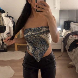 Mönstrad tubtopp - Snygg tubtopp med ett unikt mönster i blått och vitt. Perfekt för sommarens fester eller en dag på stan. Toppen är ärmlös och har en stilren design som passar till både jeans och kjol.