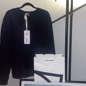 Mörkblå tröja från Dondup - Säljer en snygg mörkblå tröja från Dondup, Made in Italy. Tröjan är i nytt skick med etikett kvar. Den har en liten broderad logga på bröstet och en stilren design. Perfekt för både vardag och fest! Tag med följer, hör av er vid fler bilder och frågor!