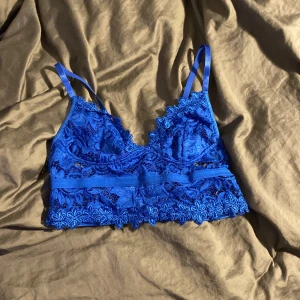 Blå spets bralette från Shein - Säljer en superfin blå spets bralette från Shein i storlek S. Den har justerbara axelband och är perfekt för sommardagar eller som ett snyggt lager under en transparent topp. Spetsdetaljerna ger en romantisk touch. Använd ett fåtal gånger, så den är i mycket bra skick.