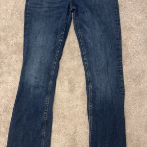 Blå jeans från Zara - Säljer ett par klassiska blå jeans från Zara i storlek EUR 40. Modellen är bootcut och är perfekta för vardagsbruk. Jeansen är i bra skick och har en knapp- och dragkedjestängning.
