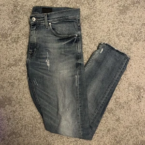 Blågrå jeans Tiger of Sweden - Säljer ett par gråblå jeans i bra skick med feta slitningar för en avslappnad look. Märke Tiger of sweden med modell pistolero.