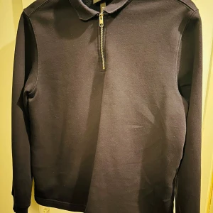 Mörkblå tröja med dragkedja från H&M - Säljer en stilren mörkblå tröja från H&M i storlek M. Tröjan har en praktisk dragkedja framtill och är långärmad, perfekt för både vardag och lite finare tillfällen. Den är i mycket bra skick och passar bra till höst- och vårsäsongen.