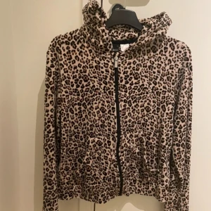 Leopardmönstrad hoodie - Säljer en supercool leopardmönstrad hoodie i mjukt material. Den har en dragkedja framtill och praktiska fickor. Perfekt för en avslappnad stil och att hålla sig varm under hösten. Passar både till vardags och chillkvällar.