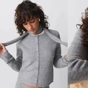Grå kofta från gina - Mysig grå kofta i mjukt material med knappar framtill. Perfekt för kyliga dagar och kan stylas både upp och ner. Den har en klassisk passform och långa ärmar. Använd 1 gång