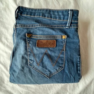 Lågmidjade jeans    - Säljer ett par lågmidjade jeans från Wrangler då dem tyvärr är lite för stora på mig. Dem är gjorda av 98% bomull och är vintage men i väldigt bra skick (inga slitningar/missfärgningar) ☺️Storleken skulle jag säga är ungefär 36/38