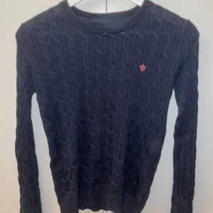 Marinblå stickad Morris tröja XS - Säljer en snygg marinblå stickad tröja med en liten broderad morris logga på bröstet. Tröjan har ett klassiskt flätmönster och långa ärmar, perfekt för vintern. Säljer den på grund av att den inte kommer till användning och den har blivit för liten för mig. Den är i bra skick och passar både till vardags och lite finare tillfällen. Hör av er er vid frågor. Priset går självklart att diskutera. Mvh Hannes.