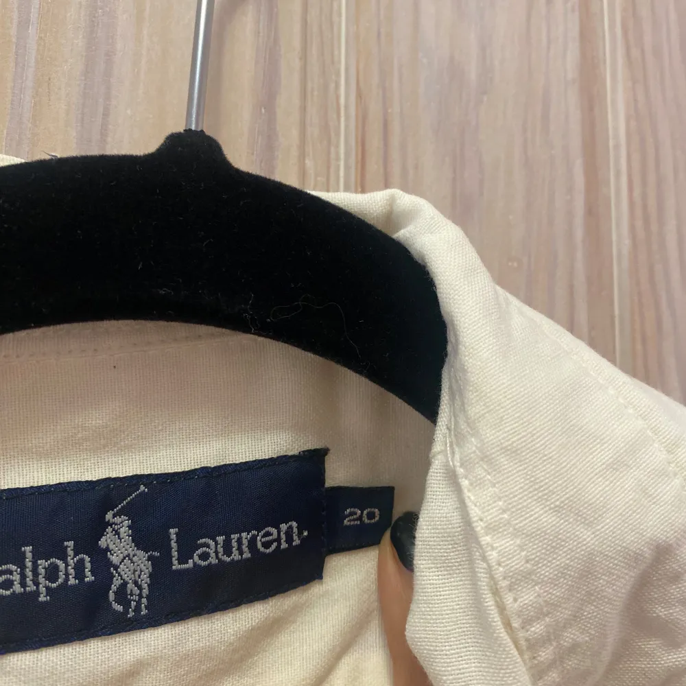 Säljer en klassisk gul skjorta från Ralph Lauren. Den har långa ärmar och en stilren design med knappar framtill. Perfekt för både vardag och festliga tillfällen. Skjortan är i bra skick och har den ikoniska loggan broderad på bröstet. Köpt i USA och storleken är 26 vilken motsvarar s/xs. Skjortor.