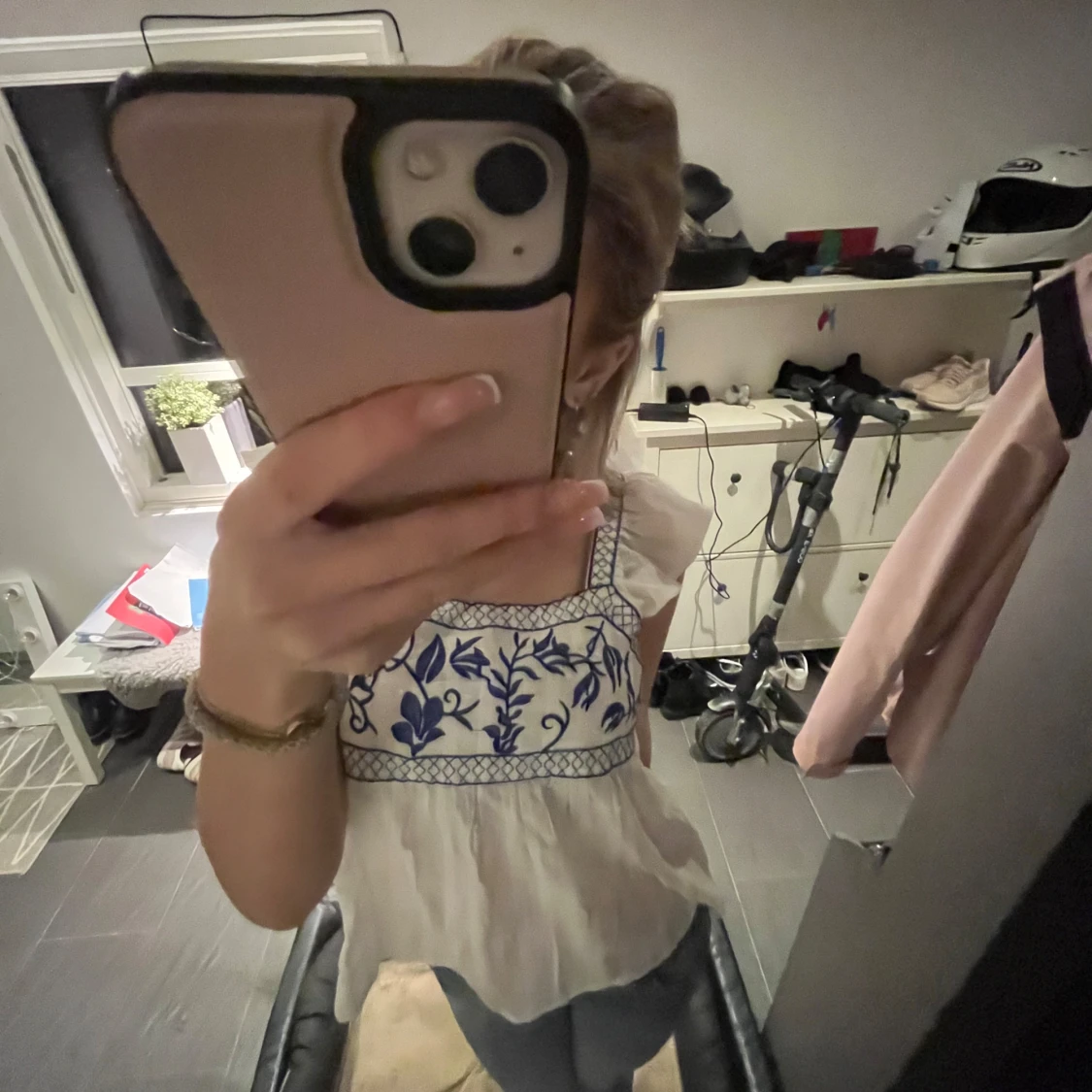 Vit blus med blått broderi