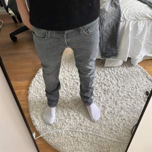 Säljer ett par grå jeans från Jack & Jones i storlek M. De har en straight passform och är i bra skick. Perfekta för både vardag och fest! 🕺