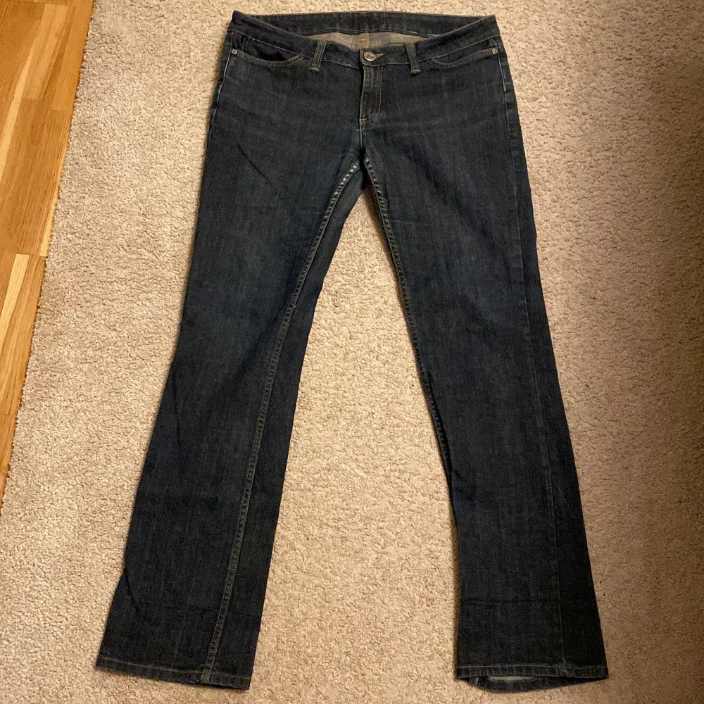 Säljer ett par mörkblå jeans i klassisk stil. De har en rak passform. Är omsydda till lågmidjade men det syns knappt. Lite slitage i grenen..Storlek 31/32. . Jeans & Byxor.