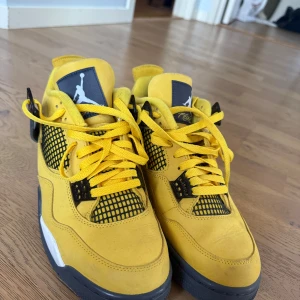 Gula Nike Air Jordans 4  - Säljer ett par snygga gula Nike Air Jordans i bra skick. De har en cool design med svarta och vita detaljer samt klassisk snörning. Köpta på pardonmykicks äkta, nästan nyskick!