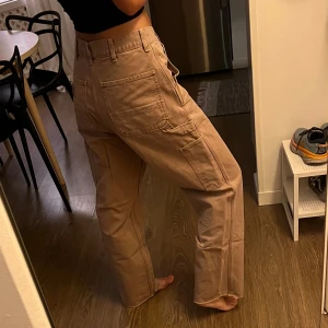 Cargobyxor från Carhartt - Gammalrosa cargobyxor från Carhartt i mycket bra skick. Har klippt av dom, så skulle säga att dom är ca 30/32 i benen. Är 168 lång.